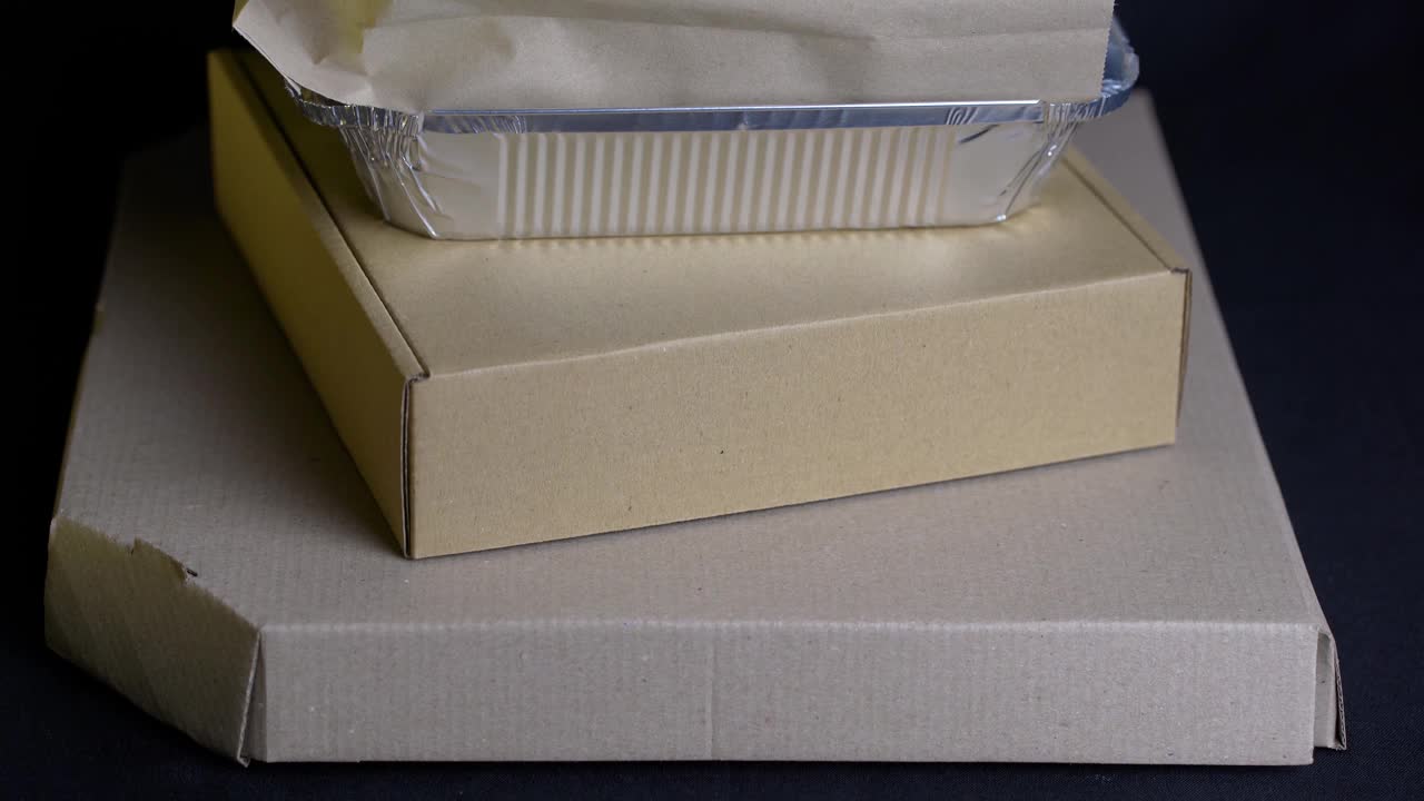 各种类型的纸盒和包装上的黑色背景。食品外卖服务视频下载