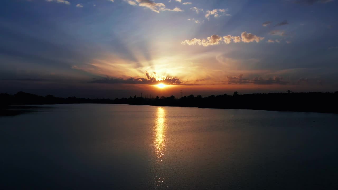 日落时湖面上戏剧性的多云天空。视频下载