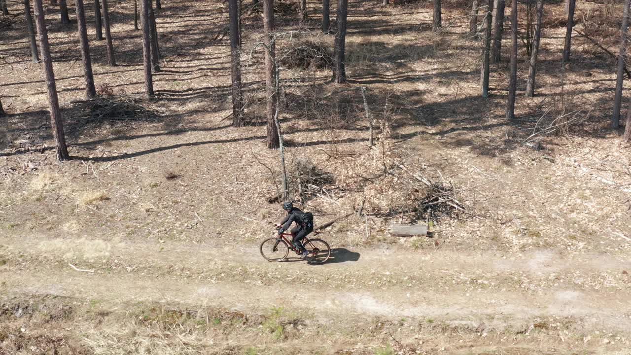 鸟瞰图的专业自行车骑在崎岖的土路在森林。视频下载