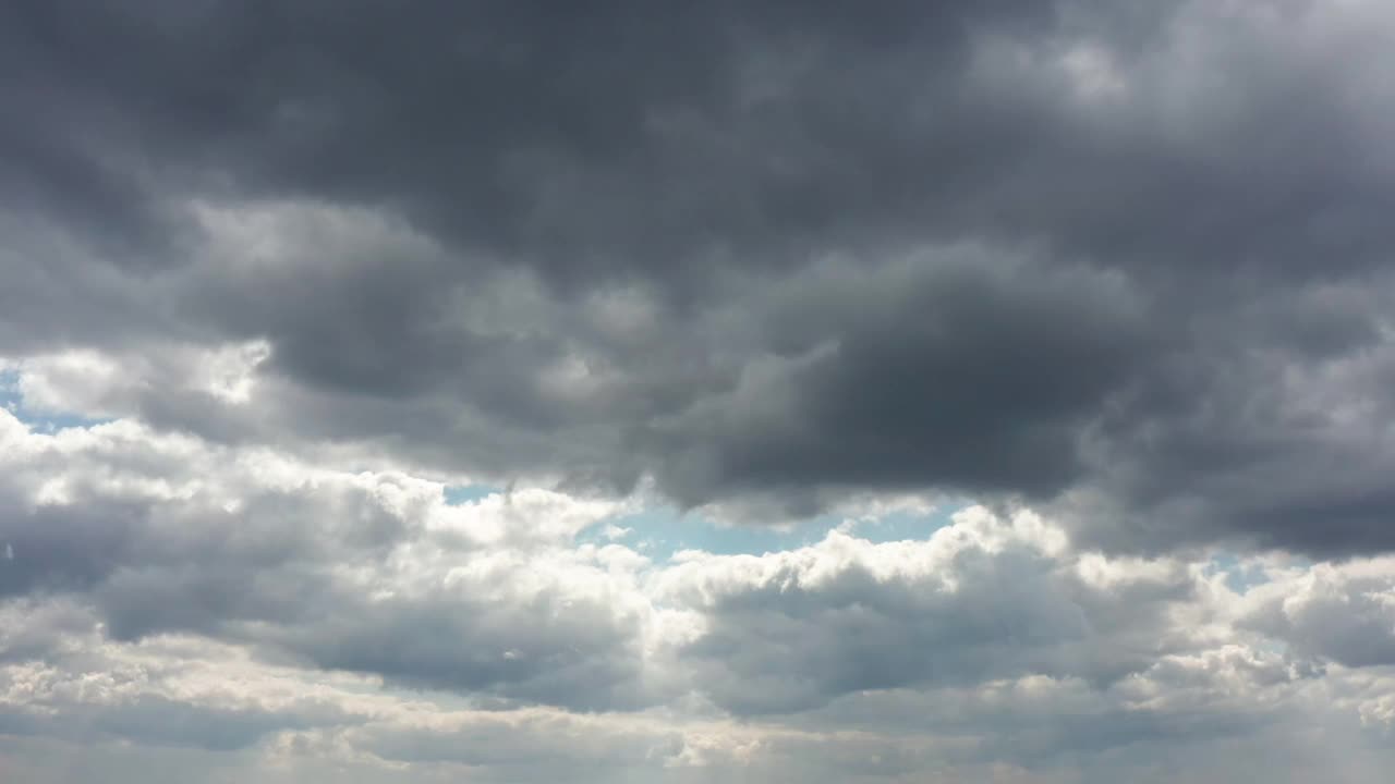 乌云密布的天空，阳光透过云层。4 k时间流逝。视频下载