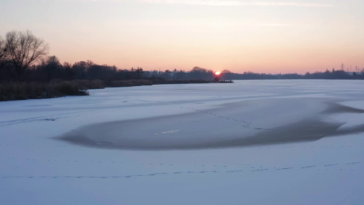 美丽的冬季景观，日出时湖面结冰。空中无人机视图。视频下载
