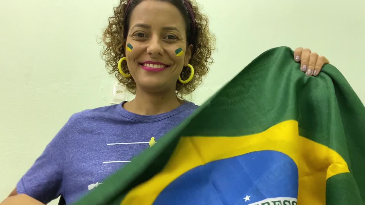 微笑的球迷挥舞着巴西国旗视频下载