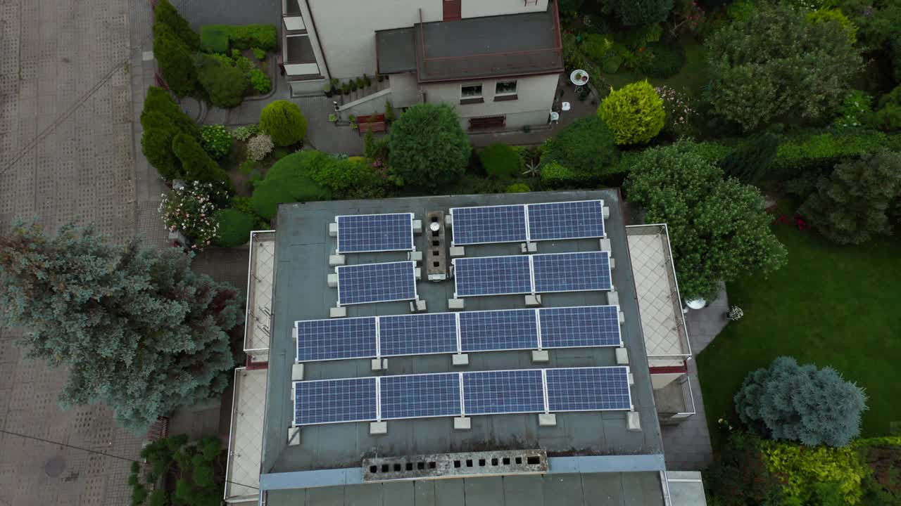 在波兰格丁尼亚的一个居民区，一架无人机飞过居民楼和安装在村舍屋顶上的太阳能电池板。视频素材