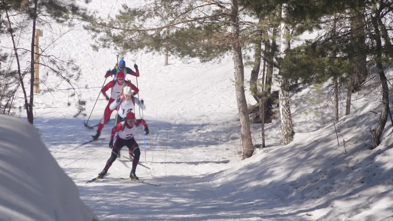 冬季滑雪运动员在森林的越野小道上滑雪上山视频下载
