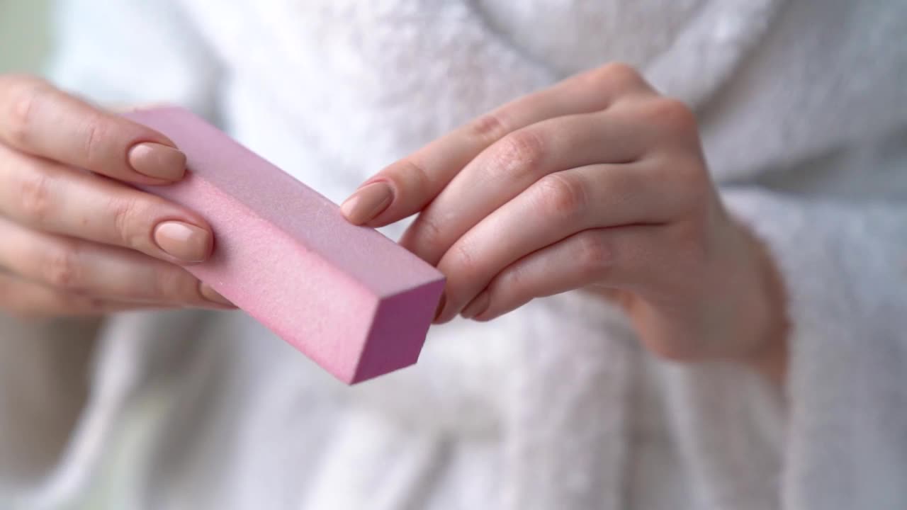 一个女人正在锉指甲，给自己做卫生的美甲。视频下载