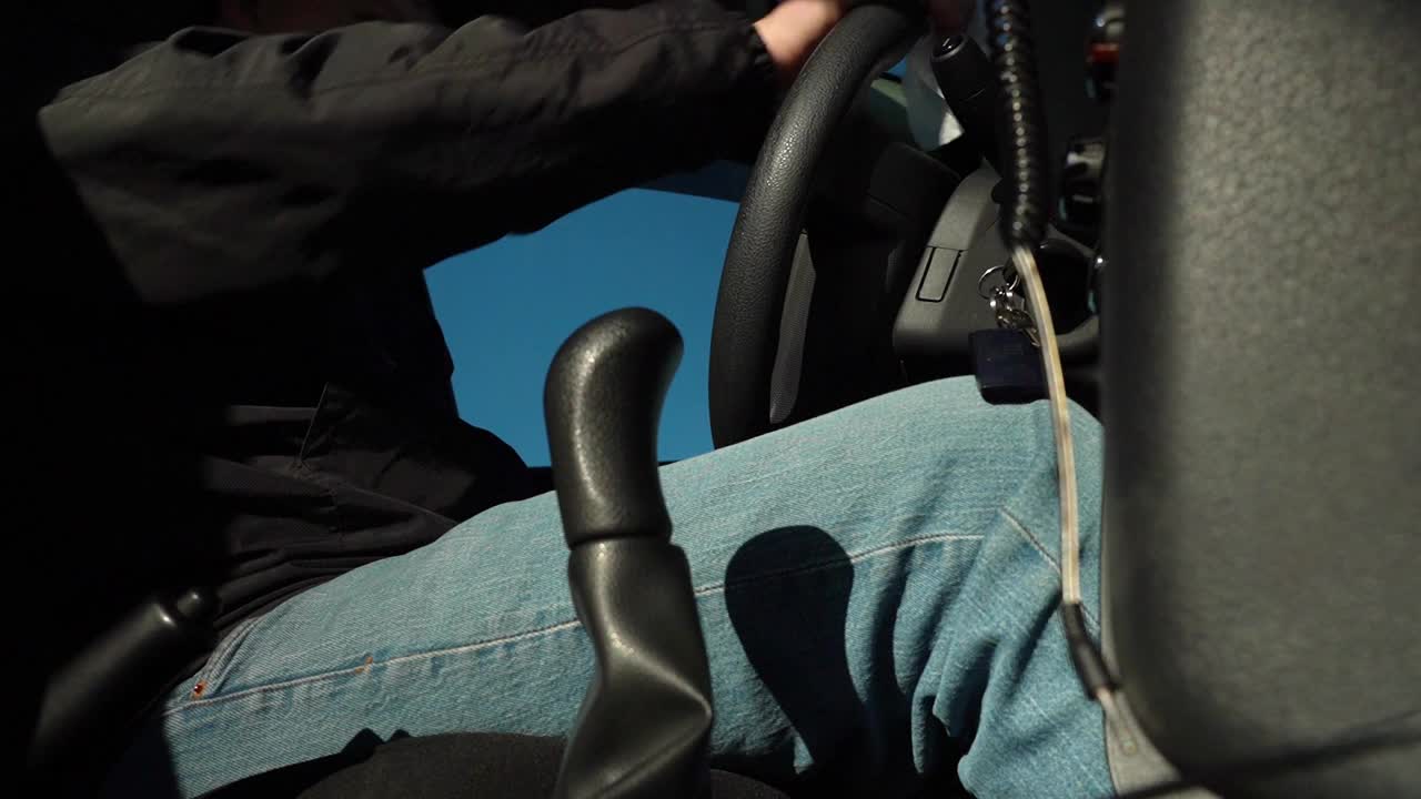 一名男子坐在车里，用消毒湿巾擦拭方向盘。底视图视频下载