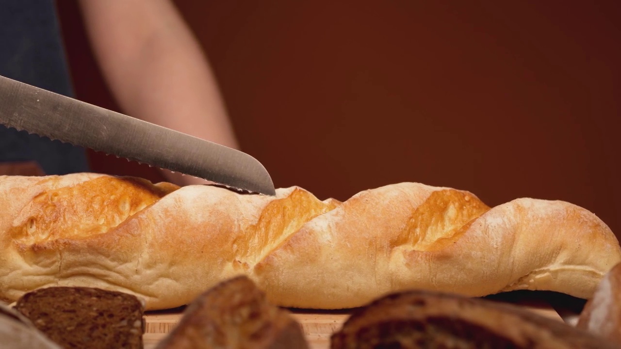 刀子在厨房桌子的切菜板上滑动自制的面包视频下载