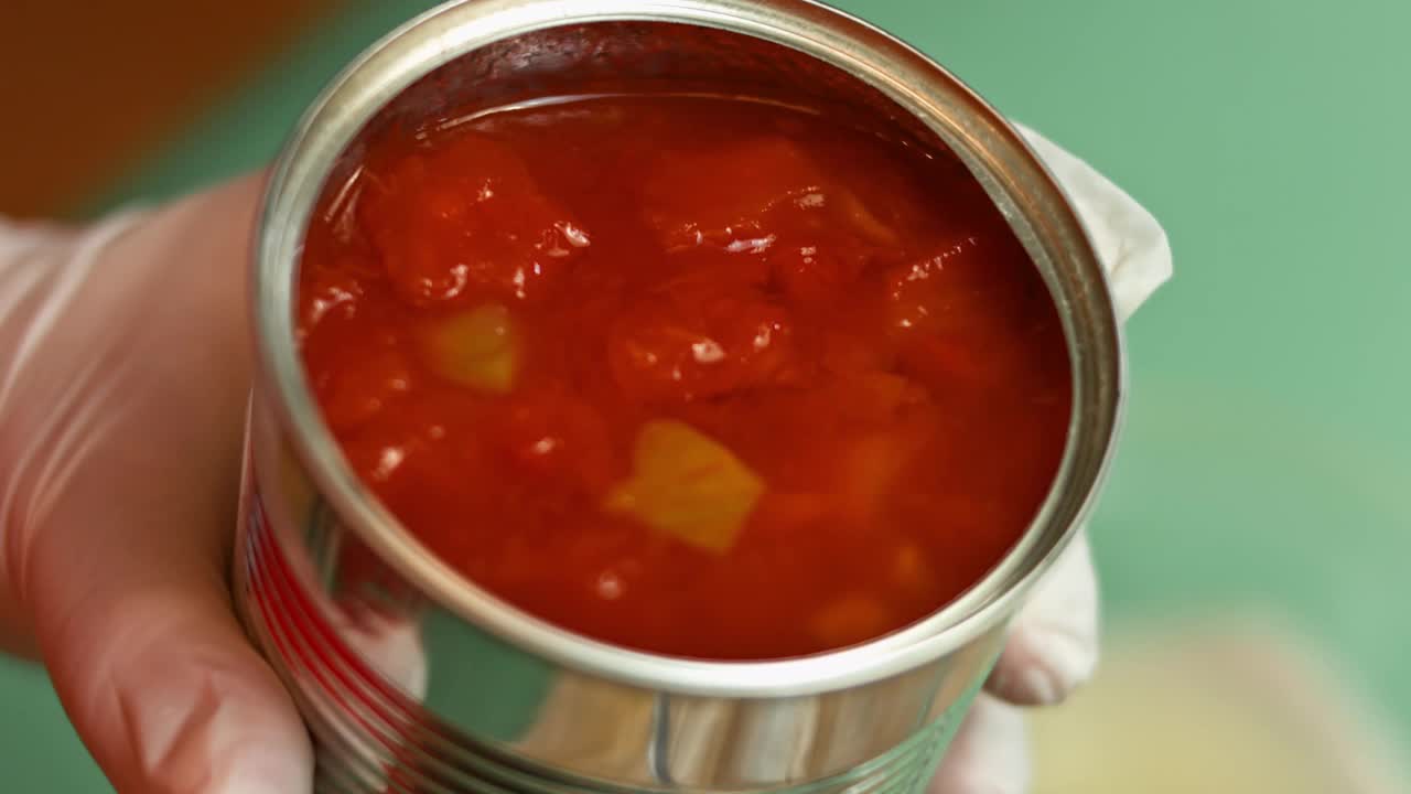 将西红柿丁从开罐倒入手动搅拌机玻璃杯中。制作萨尔萨酱的过程视频下载