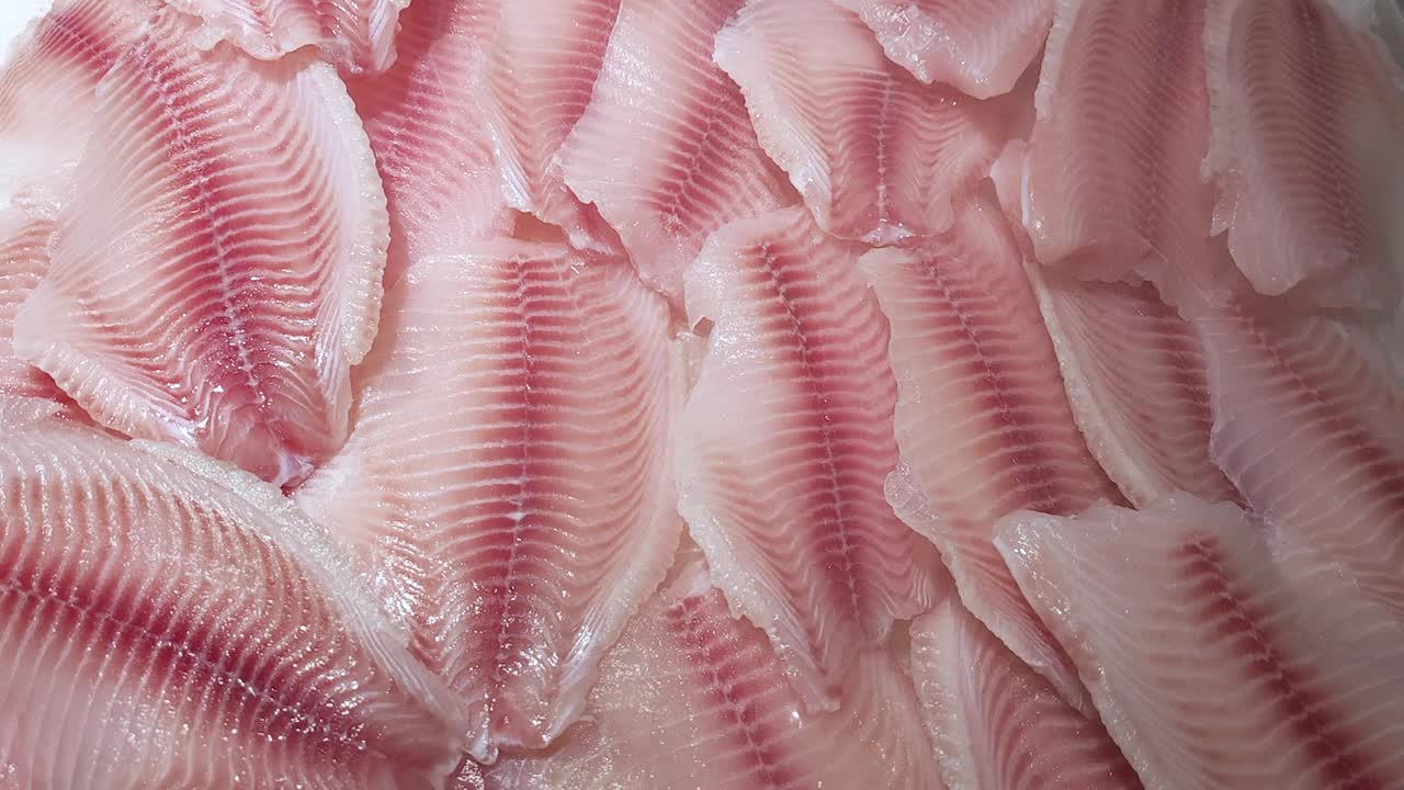 新鲜的罗非鱼片躺在商店的冰柜上，上面有冷却喷雾视频下载