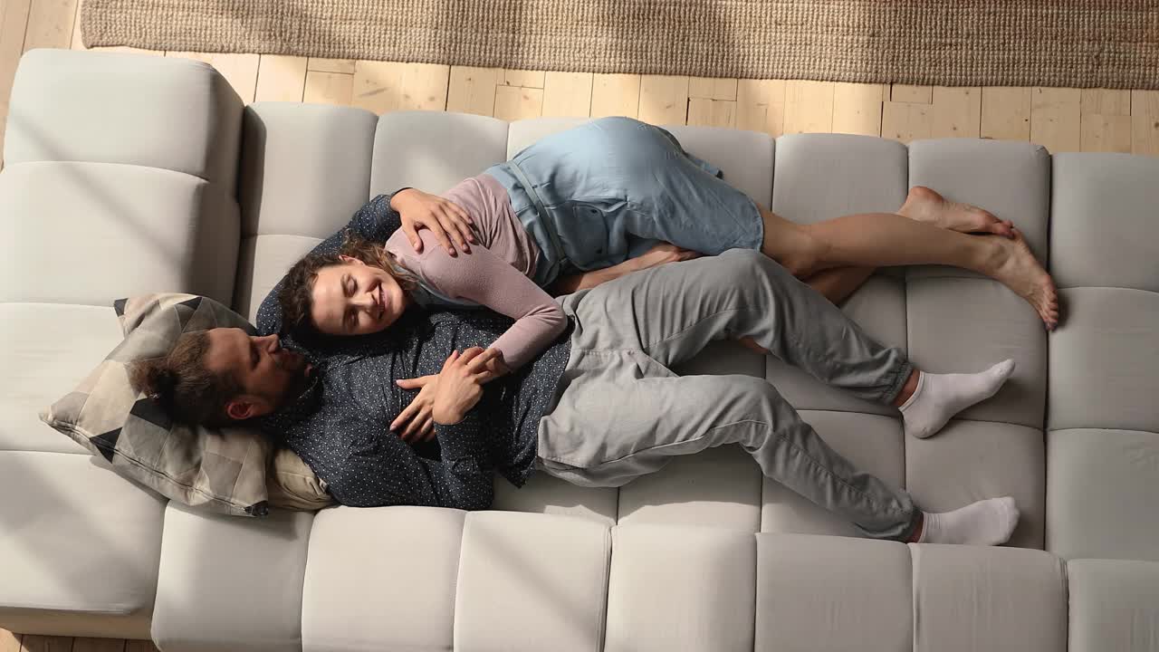 真诚相爱的夫妇在舒适的沙发上放松。视频下载