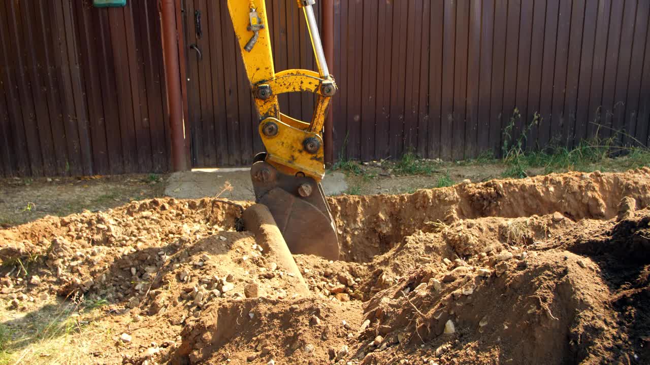 挖掘机挖出旧根，在栅栏附近挖沟视频下载