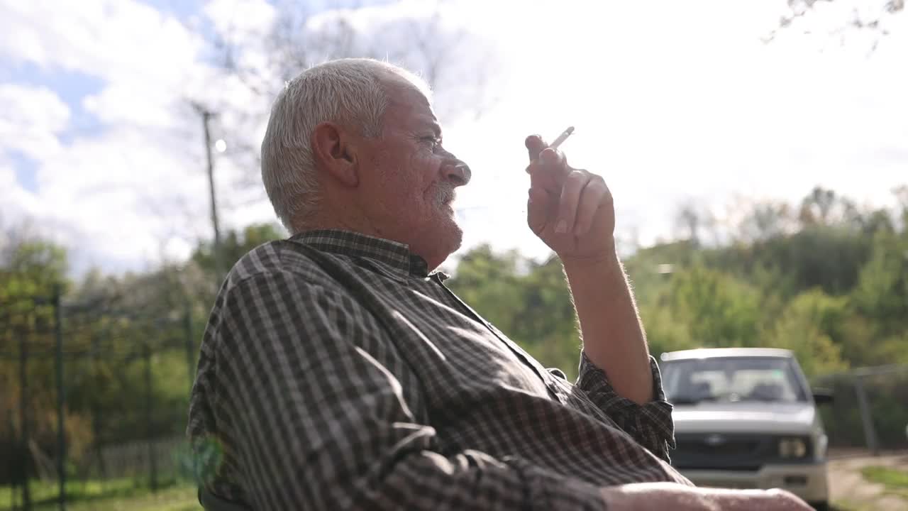 老人坐在后院，放松和吸烟视频下载