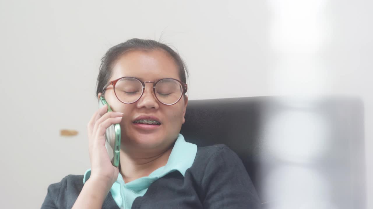 一名20-30岁的亚裔女子，穿着休闲装，正在愉快地和男友通电话视频下载
