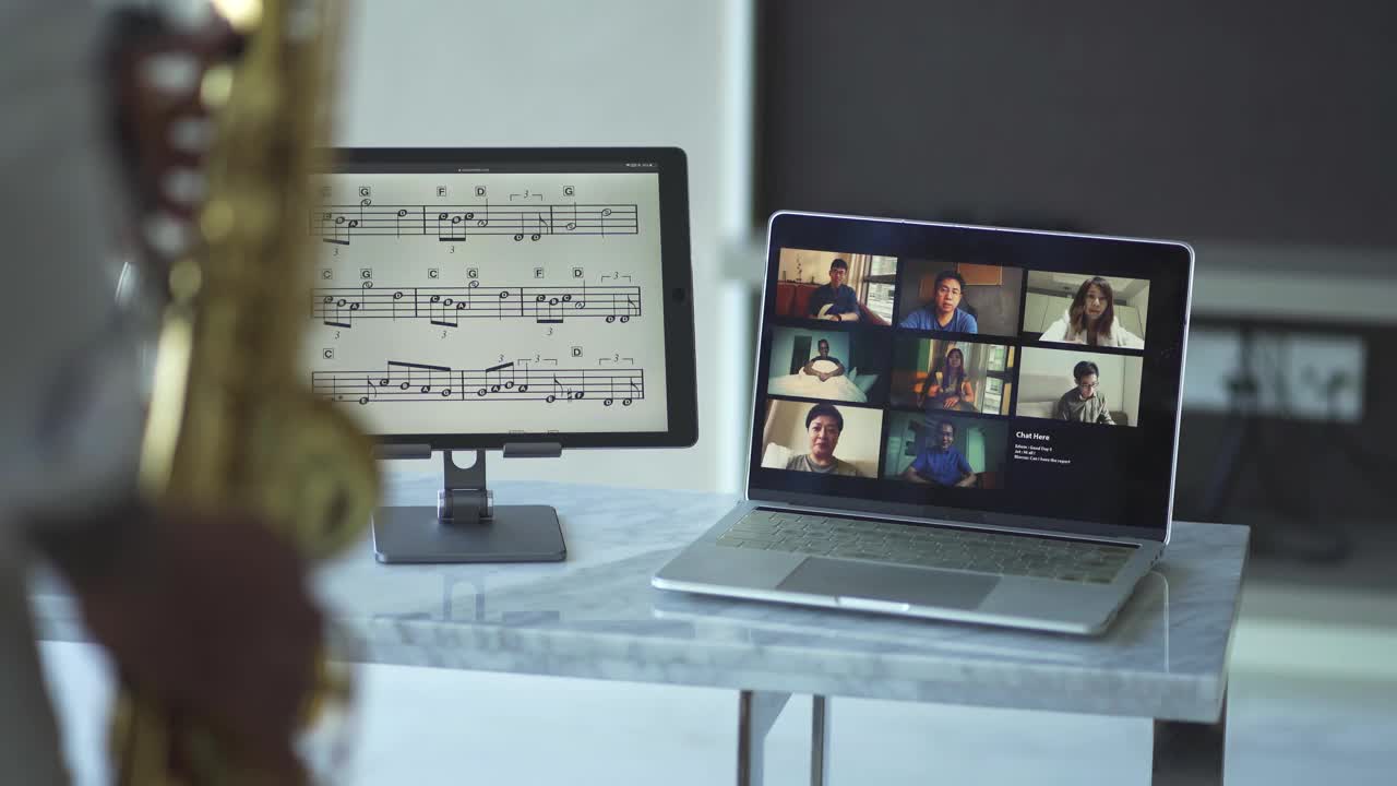 Lifehack亚洲活跃的资深艺术家演奏萨克斯管，并展示给他的学生使用笔记本电脑在客厅视频素材