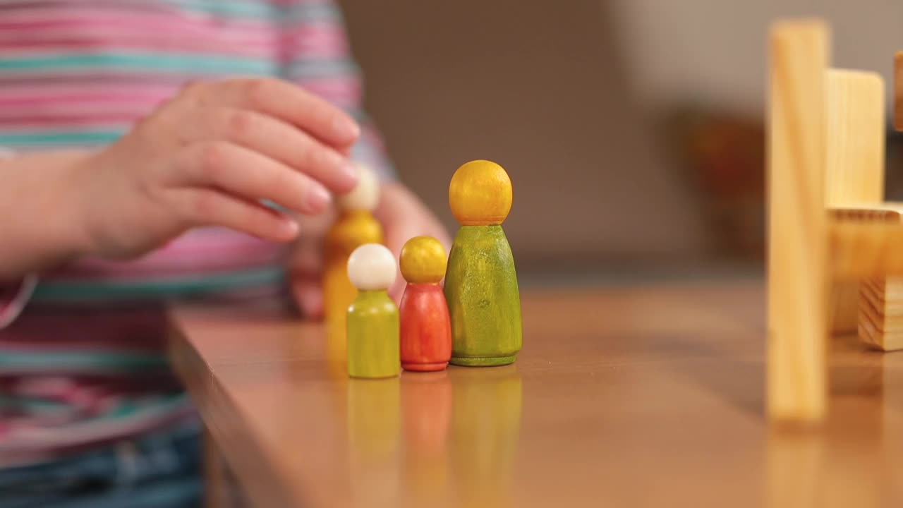 桌子上的特写木雕。孩子的手在摆弄厨房的小物件视频下载
