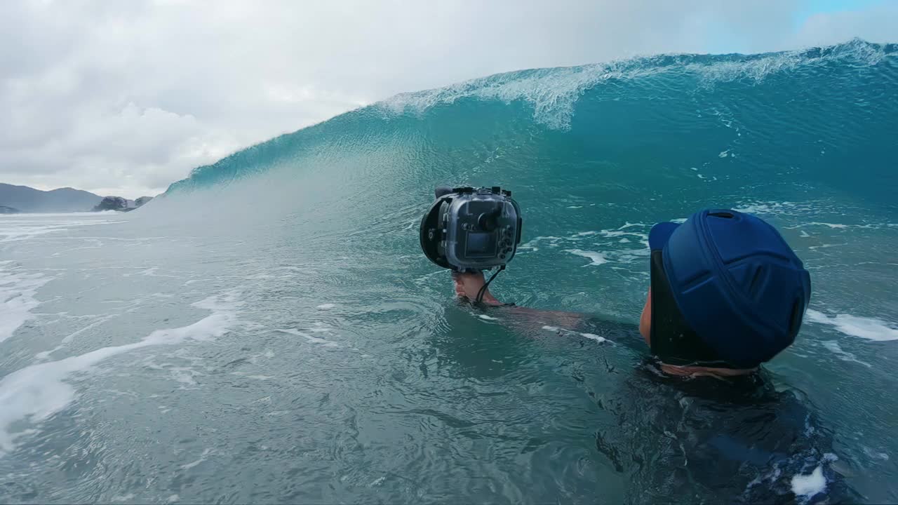 冲浪摄影师。一个带着摄像机的人拍下了破碎的波浪视频下载