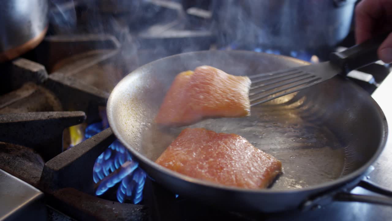 厨师在餐厅厨房里翻鲑鱼时，巨大的火焰喷涌而出视频下载