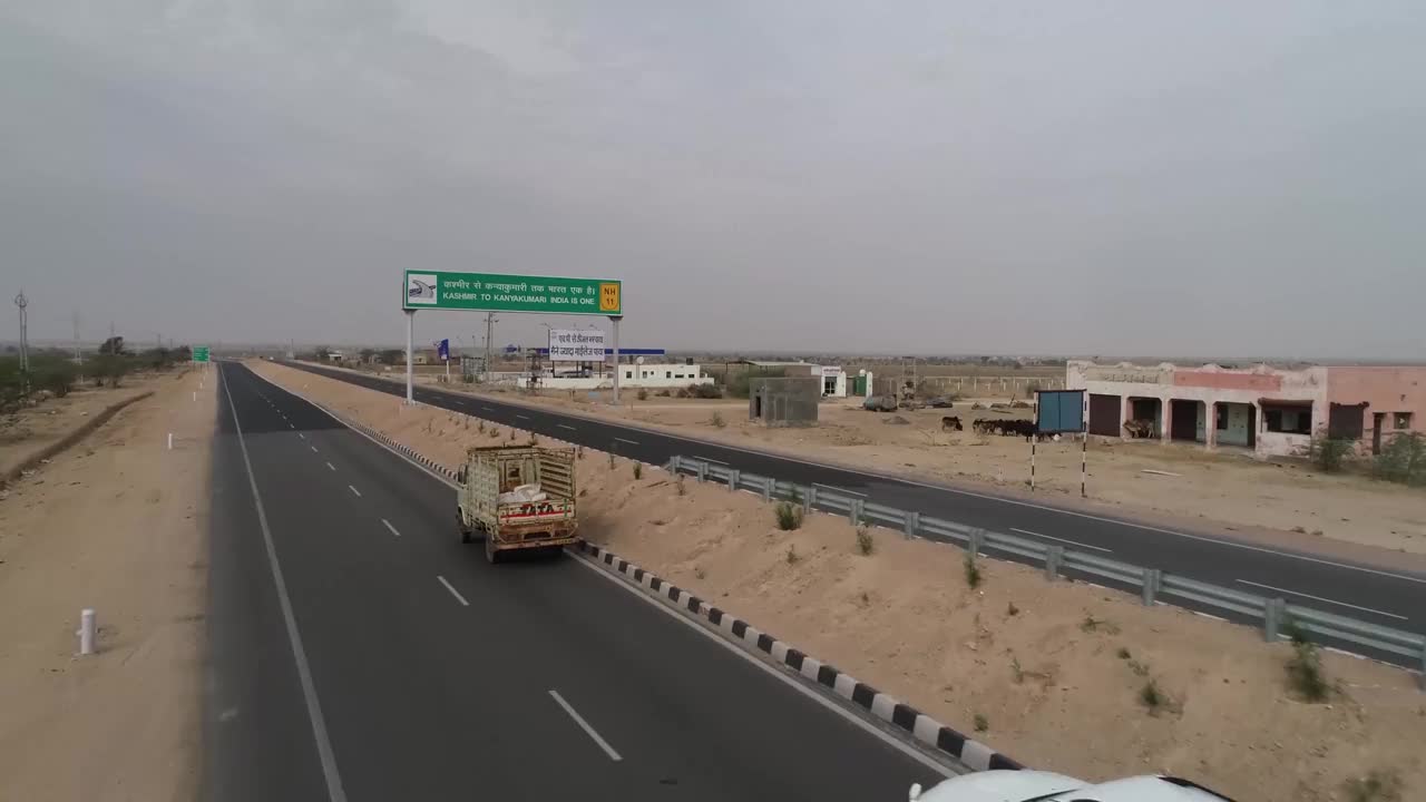 在印度拉贾斯坦邦的比卡内尔，4K无人机在11号国道上空飞过，周围是贫瘠的沙漠景观视频下载