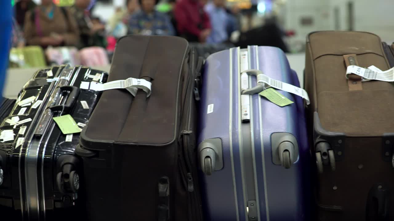 各种颜色的旅行袋或者旅客被运送到机场的传送带上。视频下载