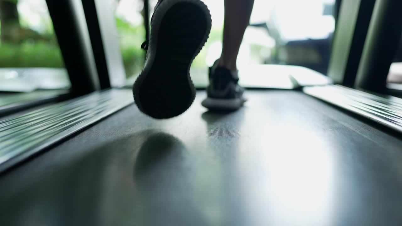 关注在跑步机上锻炼的人的腿和鞋子。视频下载