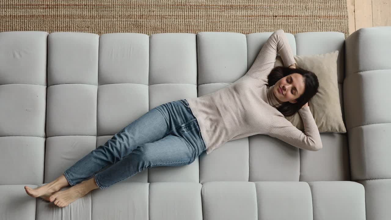 顶视图女人躺在沙发上放松在家视频下载