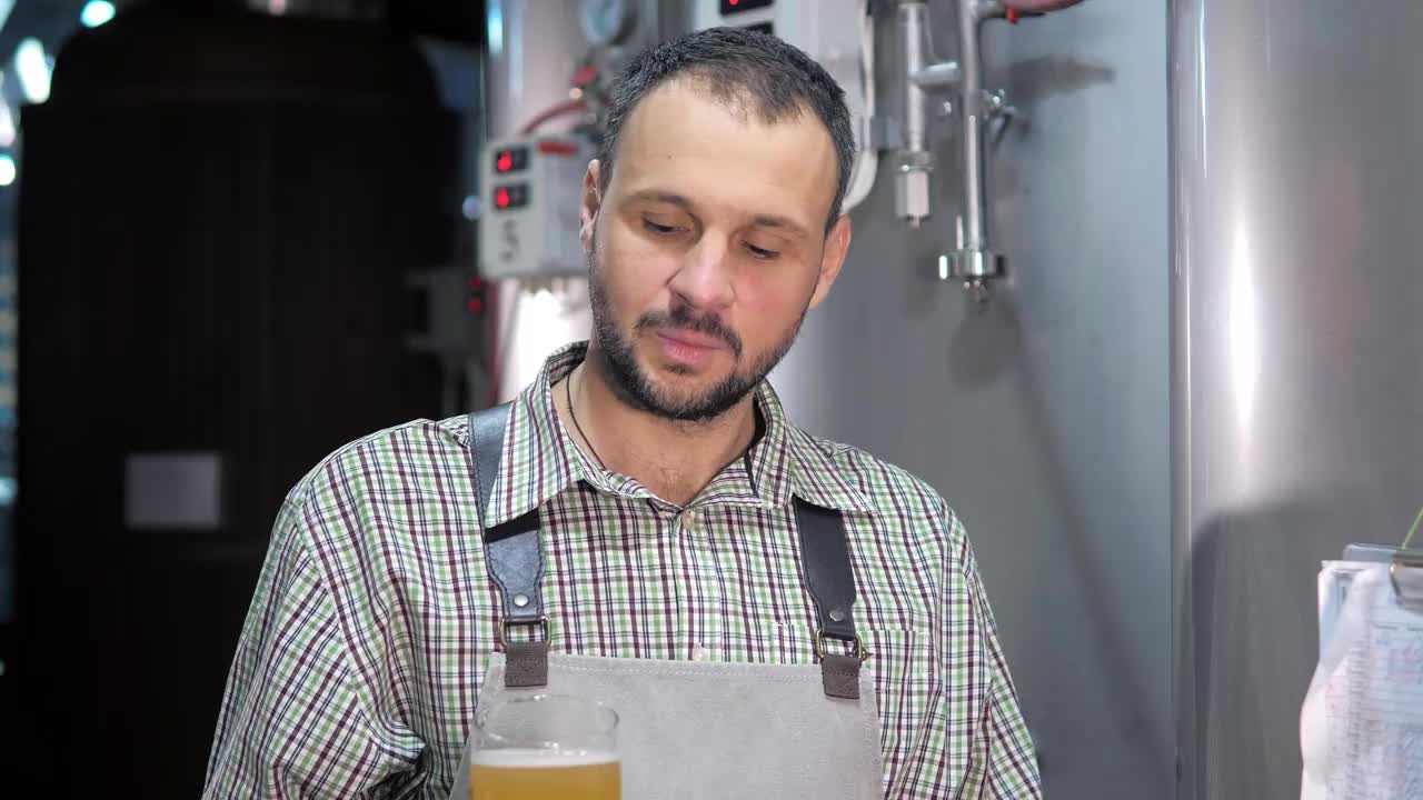 一个现代化的啤酒厂。酿酒师检查了新酿造的啤酒视频下载