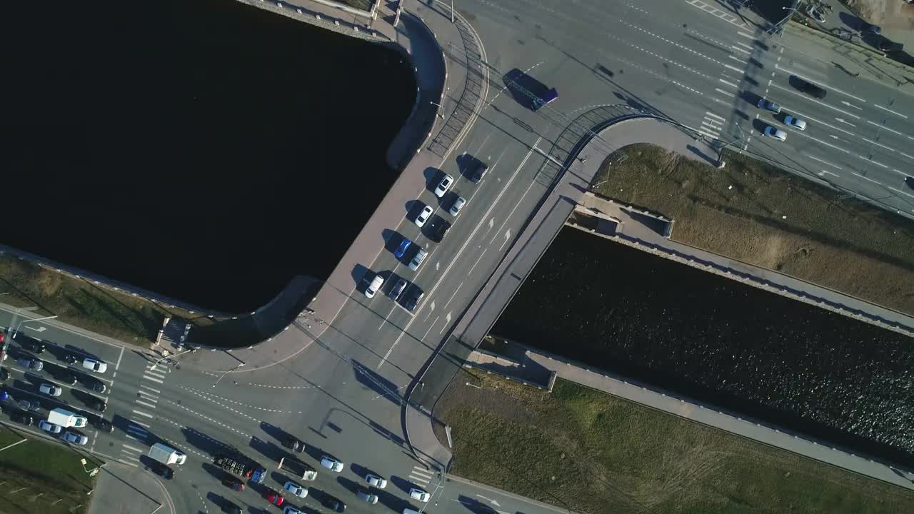 从鸟瞰图上看，俄罗斯圣彼得堡一座横跨水道的桥，汽车在桥上行驶。无人机在城市上空飞行，拍摄街道和道路的照片。视频素材