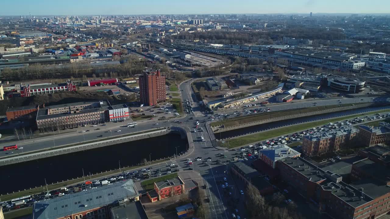 俄罗斯圣彼得堡的鸟瞰图，城市中的居民区，科技建筑，工业建筑，一座横跨水渠的桥，汽车在城市中行驶。视频素材