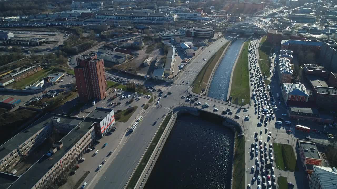 在俄罗斯的圣彼得堡，从桥上俯瞰汽车行驶的水道。无人机在城市上空高高地飞行，在俄罗斯城市工业区上空拍摄街道和道路的照片。视频素材