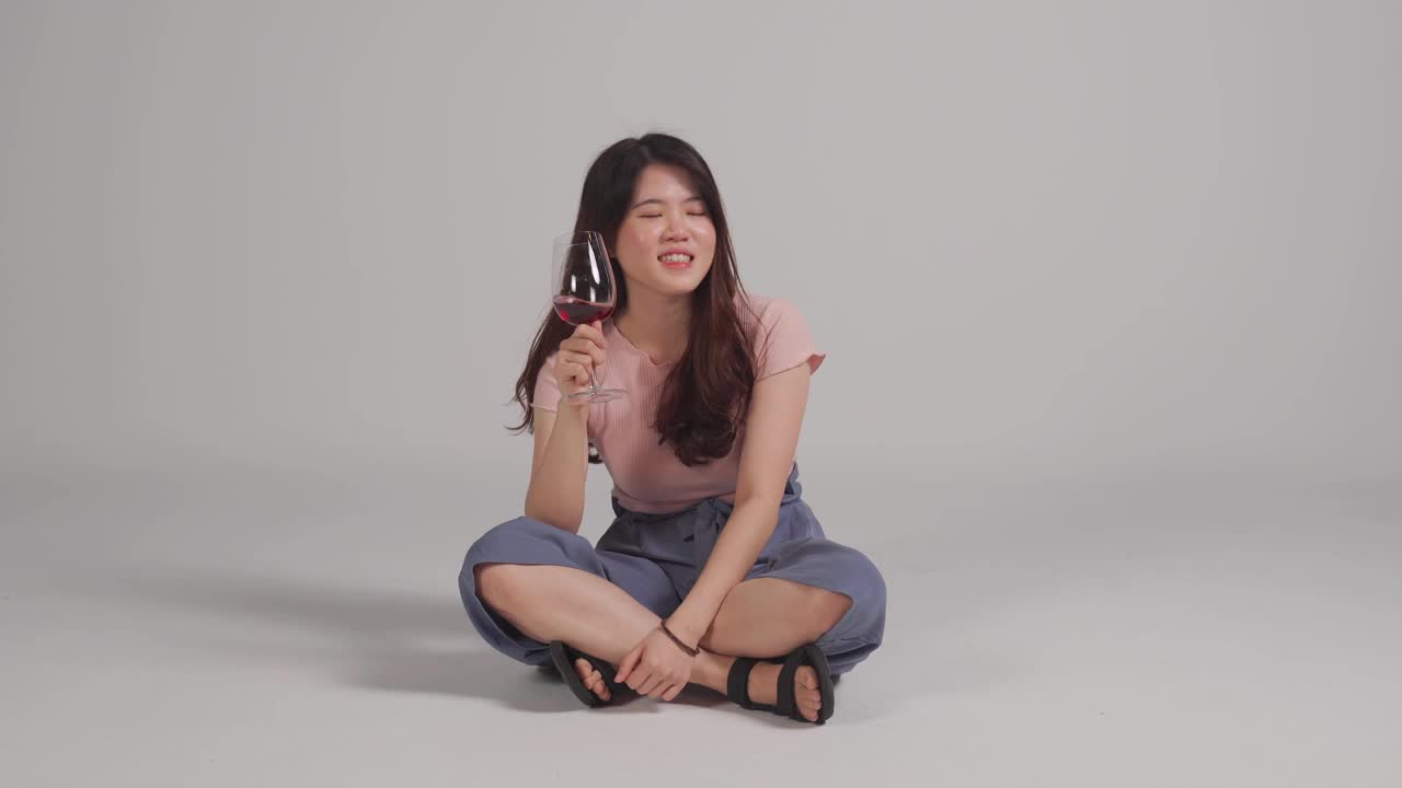 亚洲华人美女坐在地板上喝红酒享受视频下载