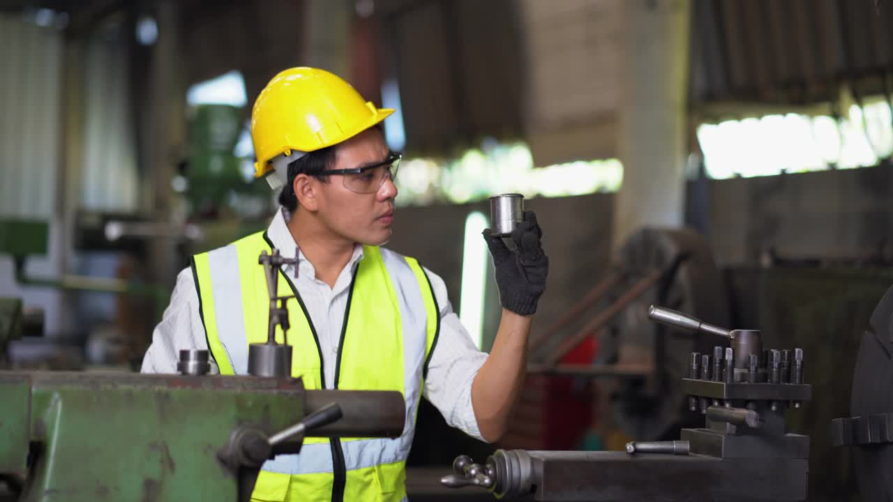 亚洲工人戴安全帽和安全眼镜与机器在工厂工作。操作车床的工业工程师视频下载