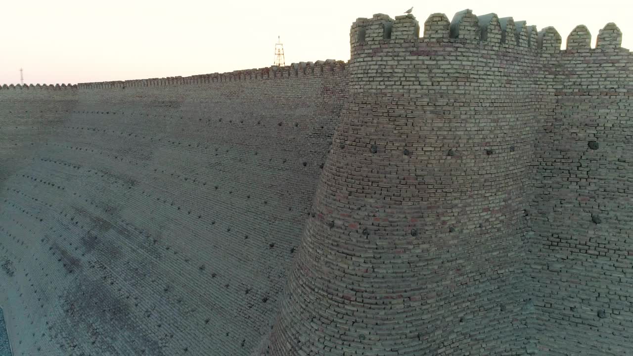 航拍:日落时分，乌兹别克斯坦布哈拉城著名堡垒的巨大城墙特写视频下载