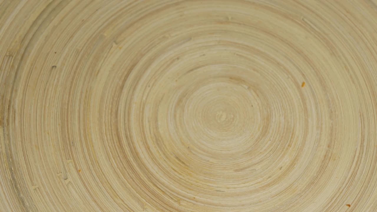 金色的薯条被倒进一个旋转的木盘子里。从上面的观点视频下载