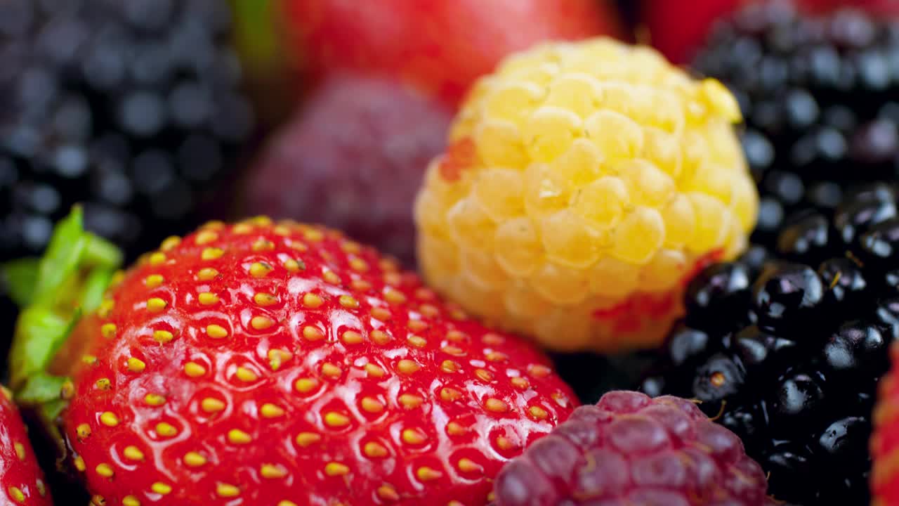 近距离4k多莉视频草莓，覆盆子，蓝莓和黑莓在桌子上。完美的抽象背景烹饪或健康的食物。视频下载