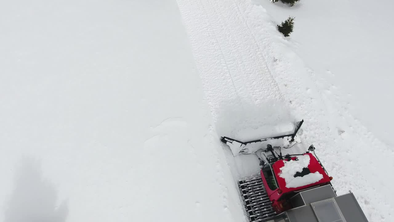 顶部，鸟瞰图的雪车骑在白色的未受影响的新鲜雪在山上的松树。雪地车作为滑雪胜地的免费交通工具视频下载