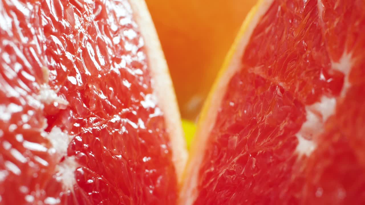 镜头的特写镜头移动两半新鲜切橘子或葡萄柚。有机食品和健康营养的完美抽象镜头。柑橘类水果的特写视频下载