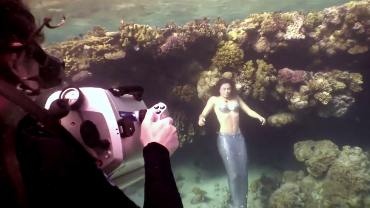 摄影师拍摄视频年轻女子水下美人鱼模型。视频下载