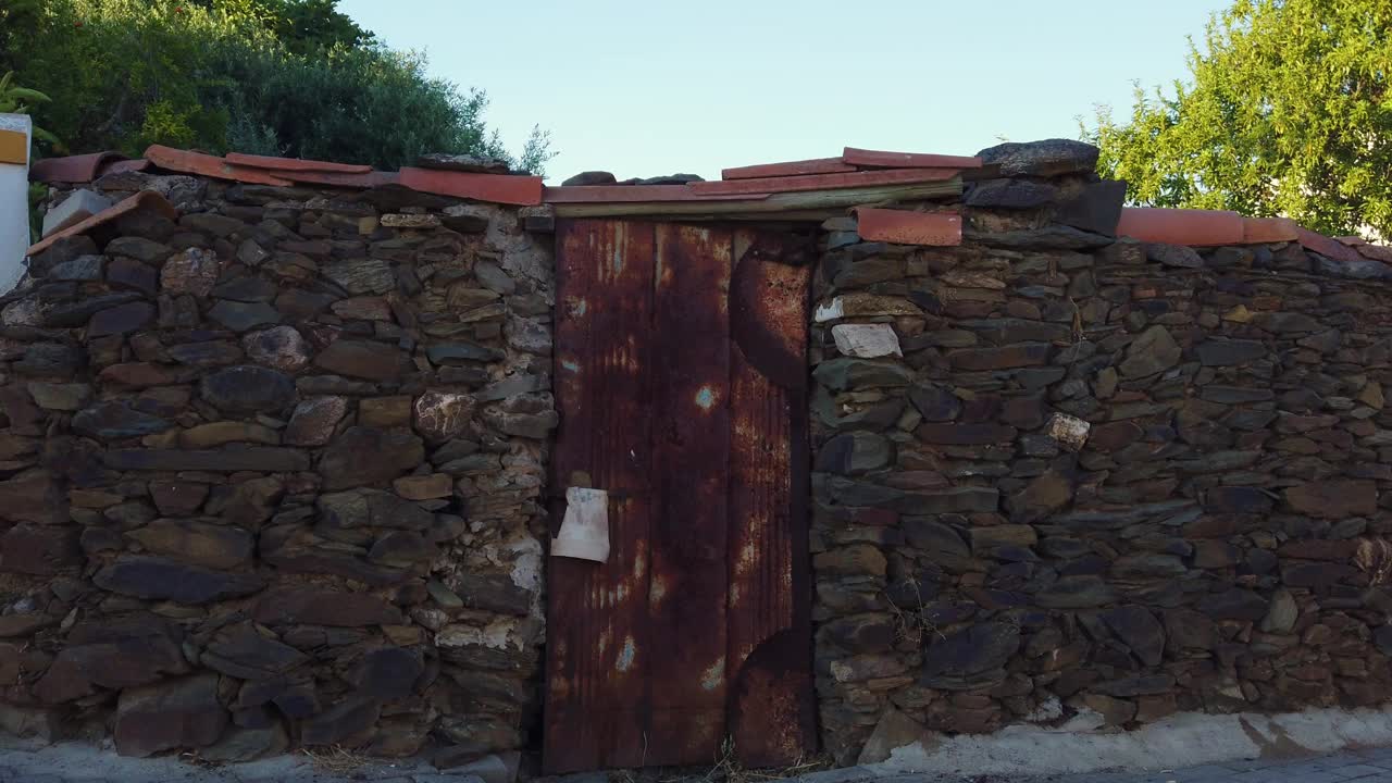 一扇生锈的老门，四周是石墙视频素材