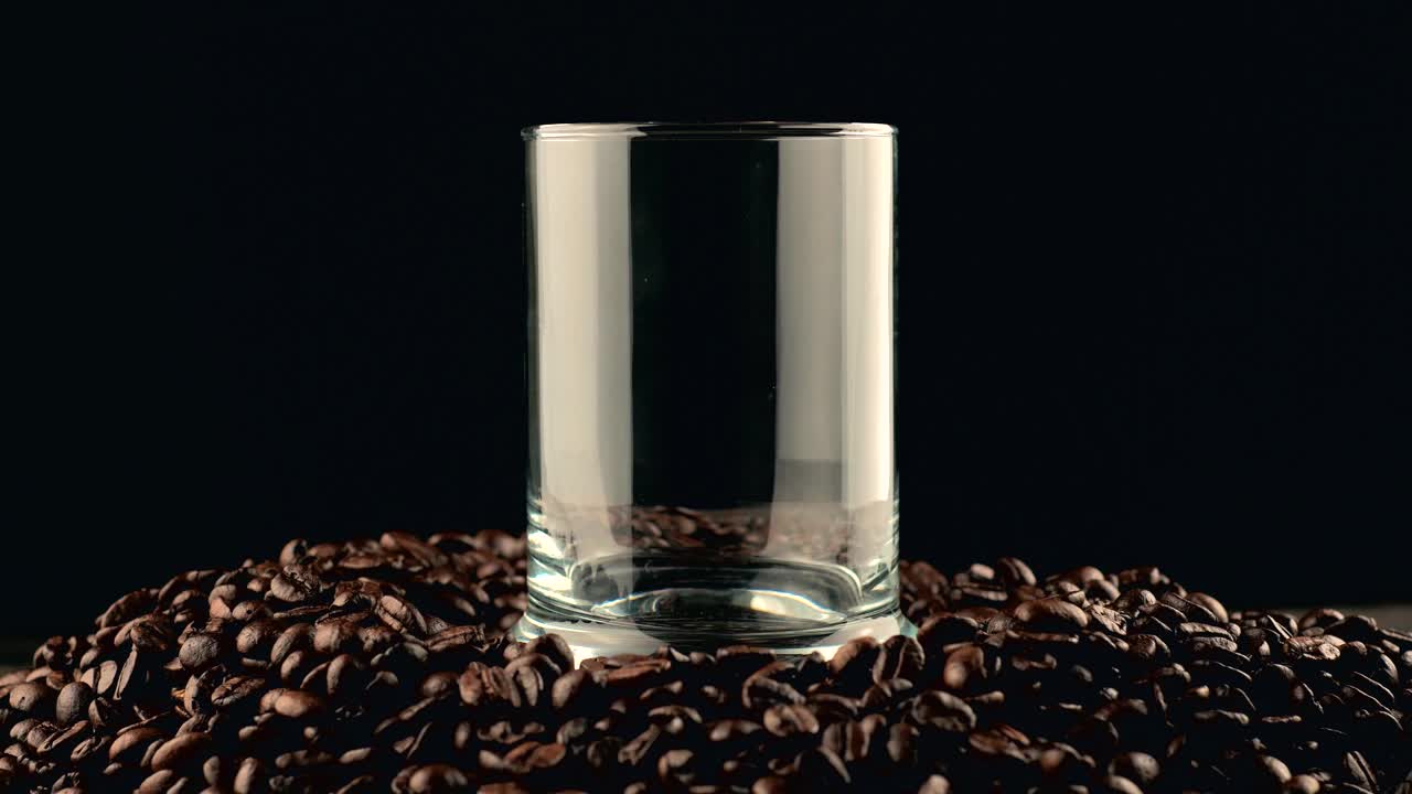 近距离镜头倒可乐在杯子咖啡豆的背景。视频下载