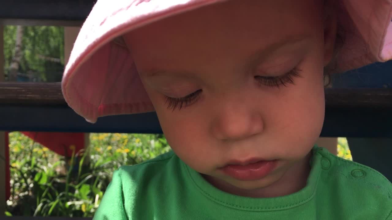 一个戴着粉色巴拿马草帽的小女孩在一个阳光明媚的夏日漫步探索大自然视频下载
