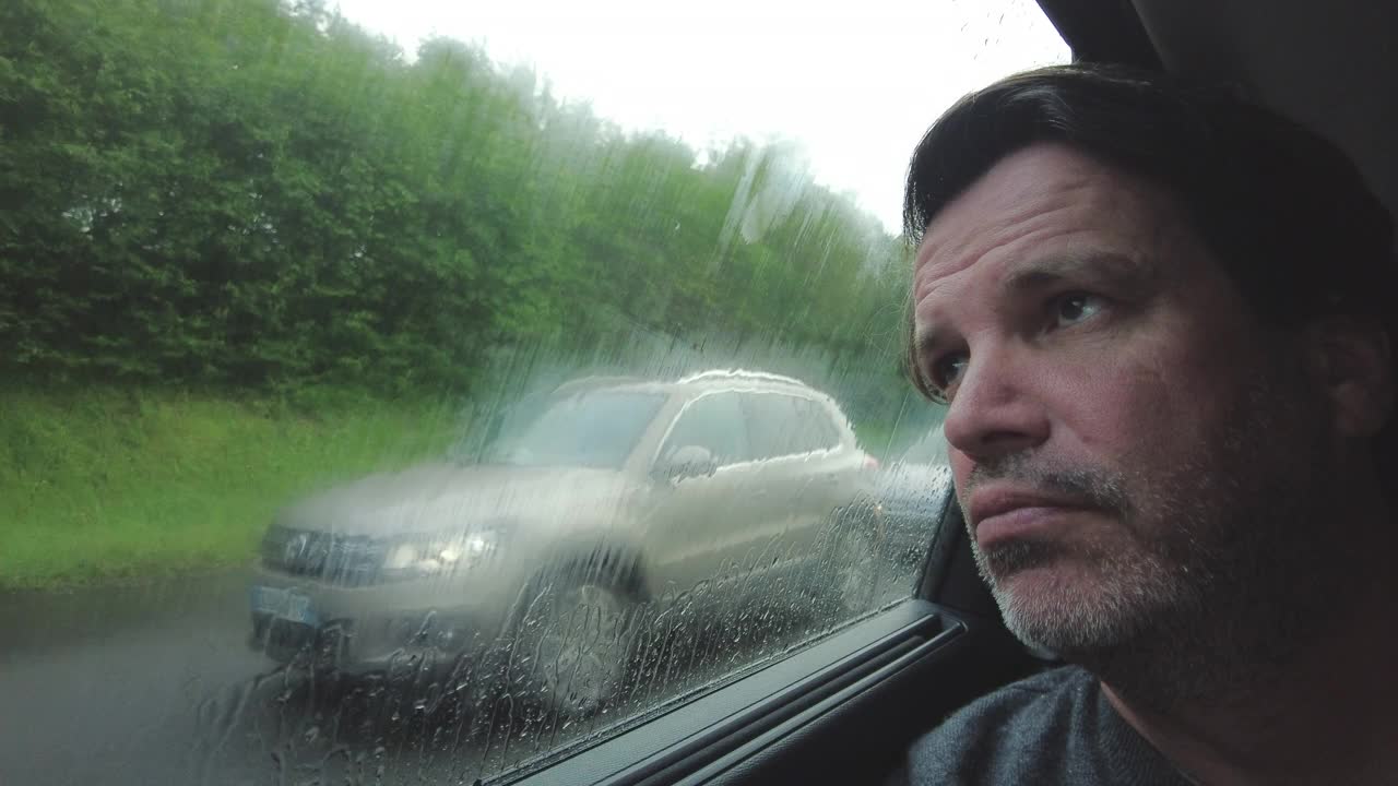 一个男人坐在车里透过窗户看风景视频下载