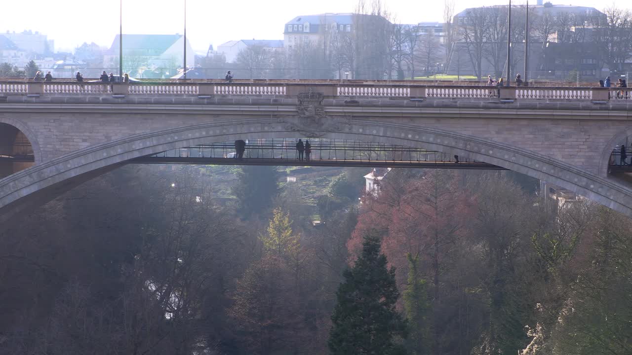 白天，卢森堡城市阿道夫大桥上的车辆和行人视频下载