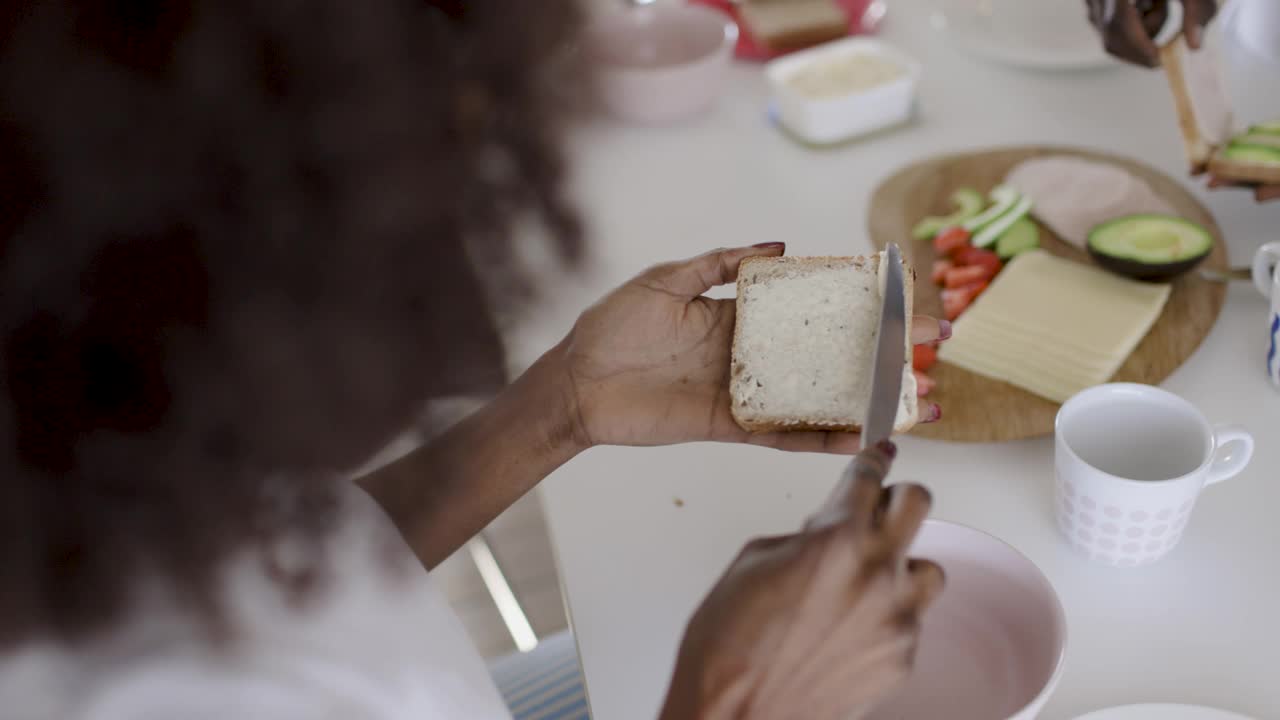 女人在切片面包上涂黄油视频下载