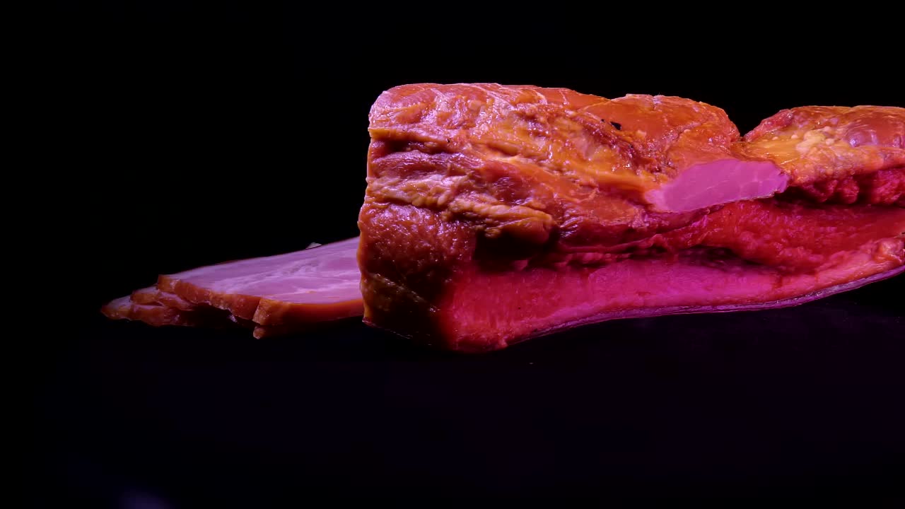 黑色背景上的一块煮熟的猪肉视频下载