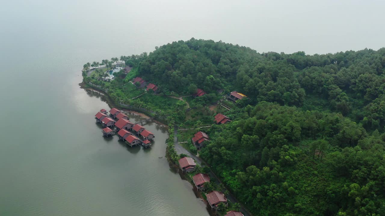 空中拍摄高跷度假胜地在坝考海湖绿树，无人机飞过景观-顺化，越南视频下载