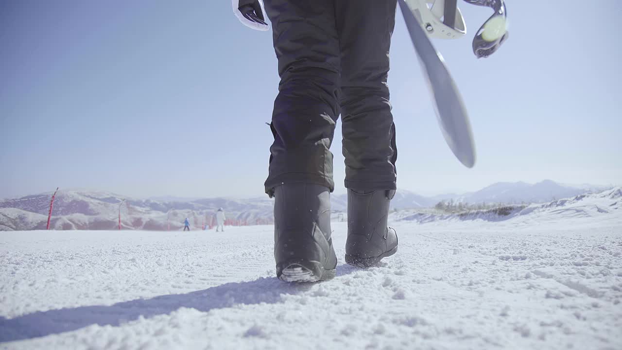 年轻女子带着滑雪板在雪地上行走，4K视频素材