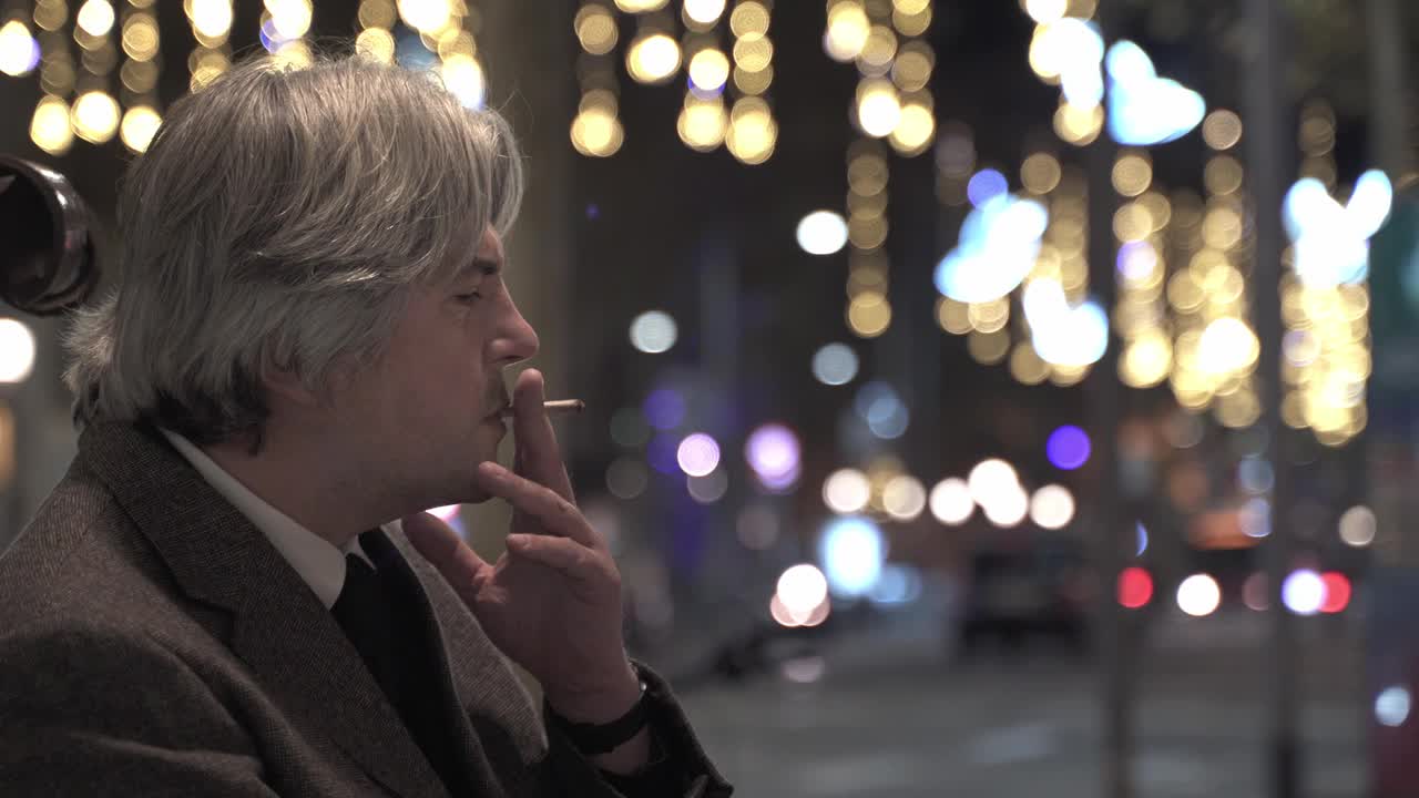 沉思的中年商人晚上在繁忙的城市吸烟视频下载