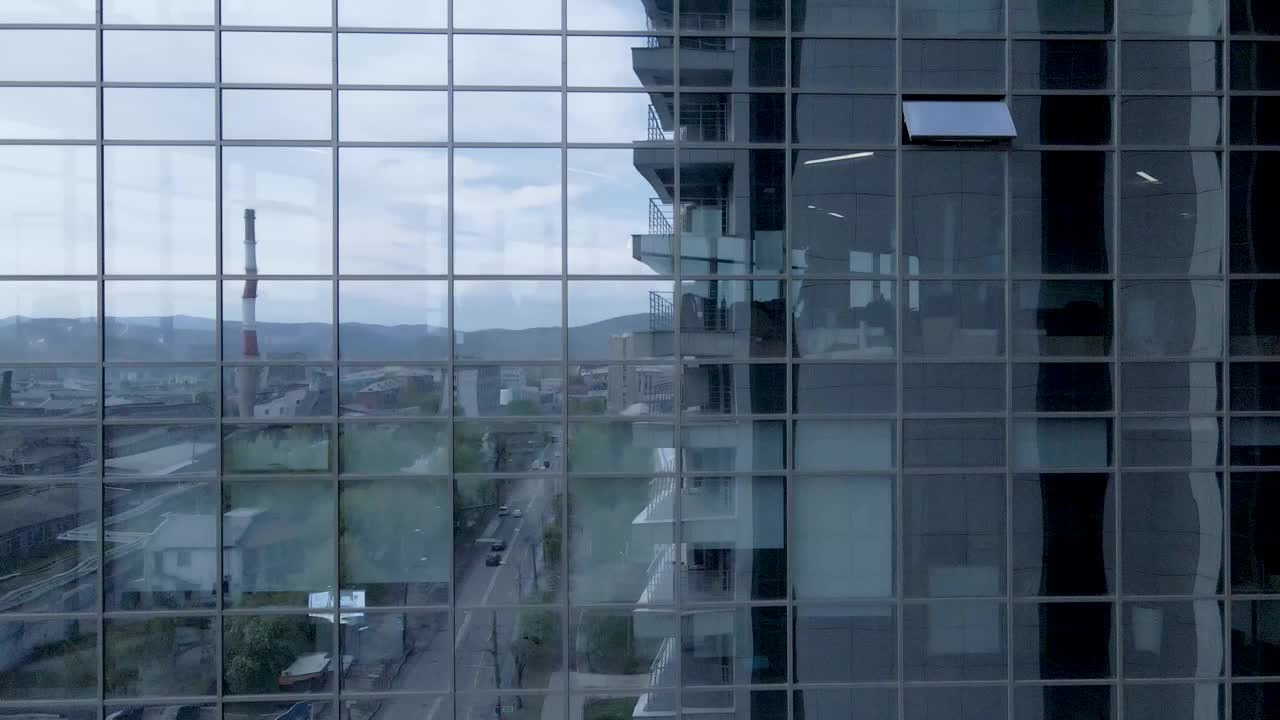 反射窗口的商务办公室特写，蓝色背景。技术和工业工作的人在办公室，工作日，从无人机拍摄视频素材
