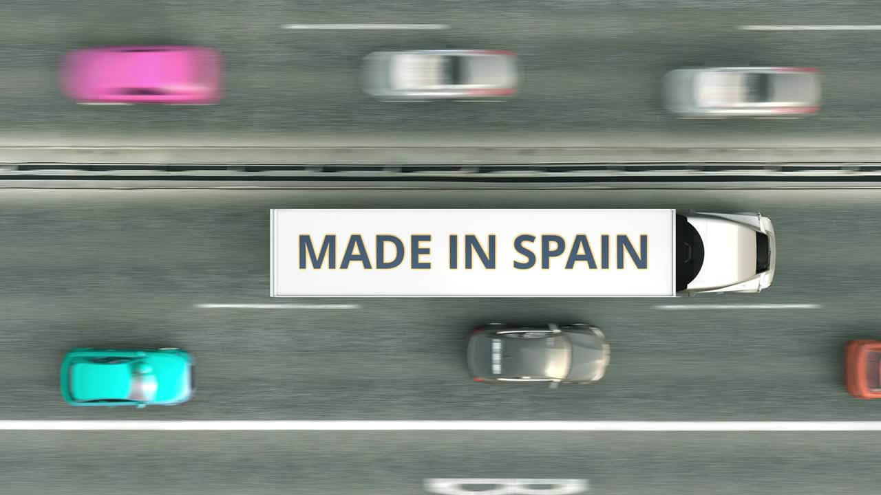 带有西班牙制造文字的拖车卡车在路上行驶视频下载