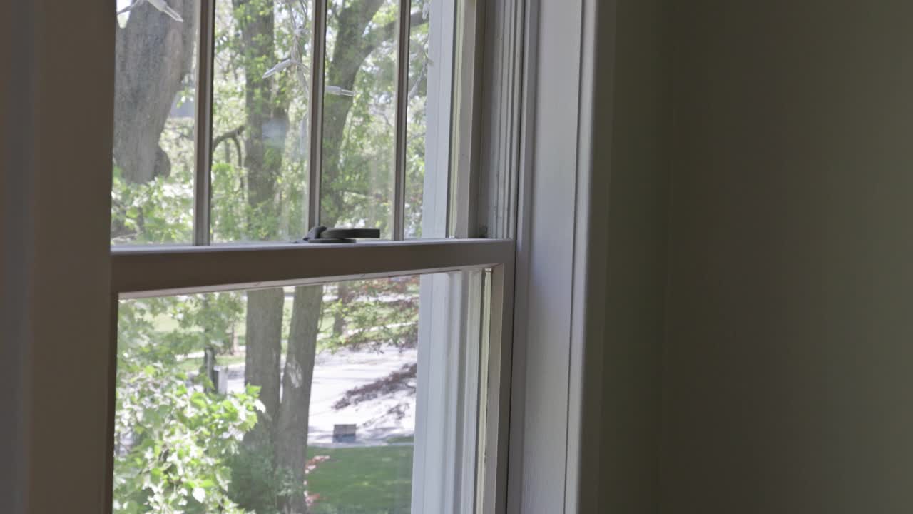 工人用油漆滚筒在窗框上涂上一层白色的镶边视频下载